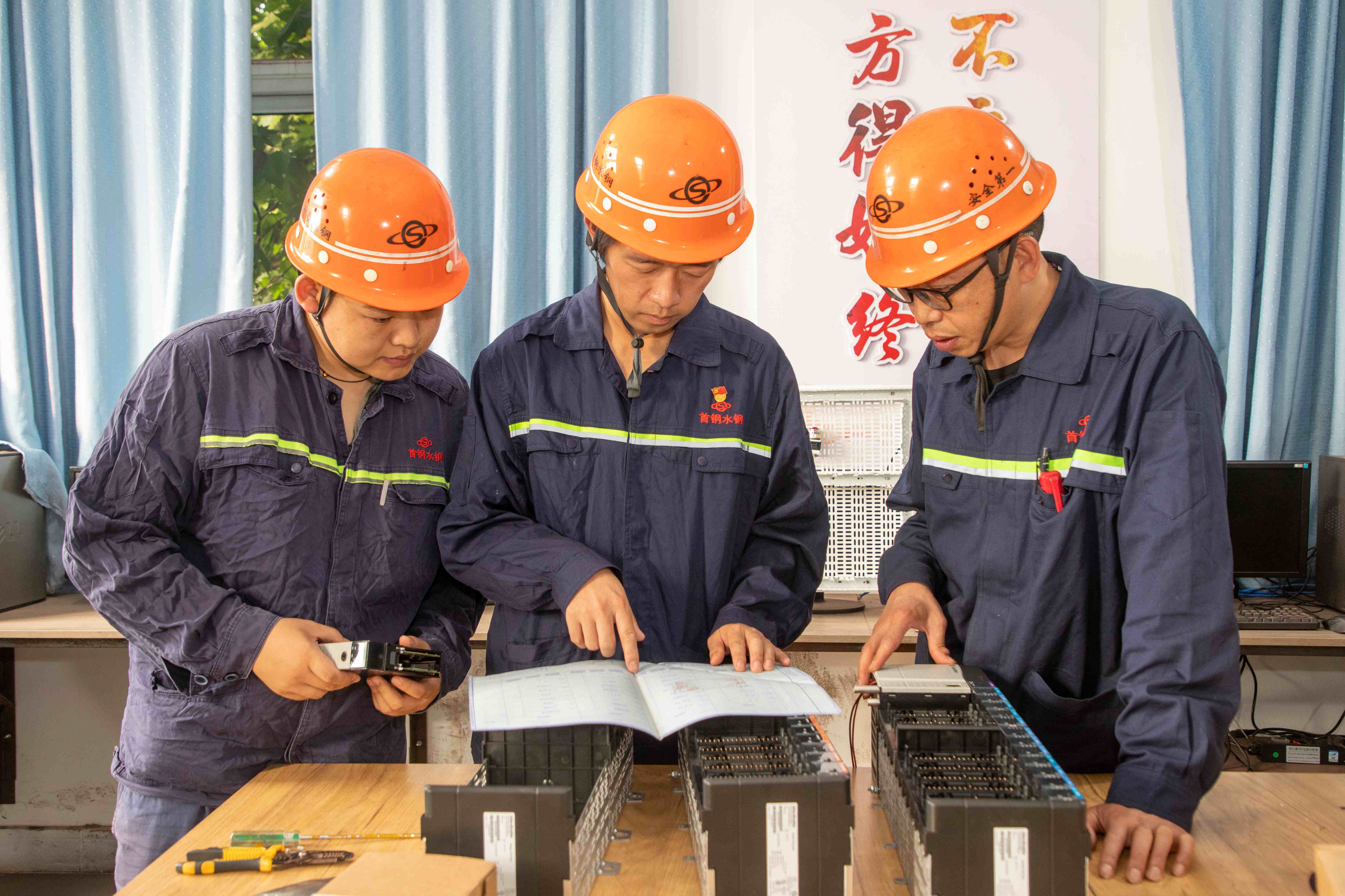 付雷(中)与工匠场成员在研究探讨设备自动化升级改造——杨德清 摄